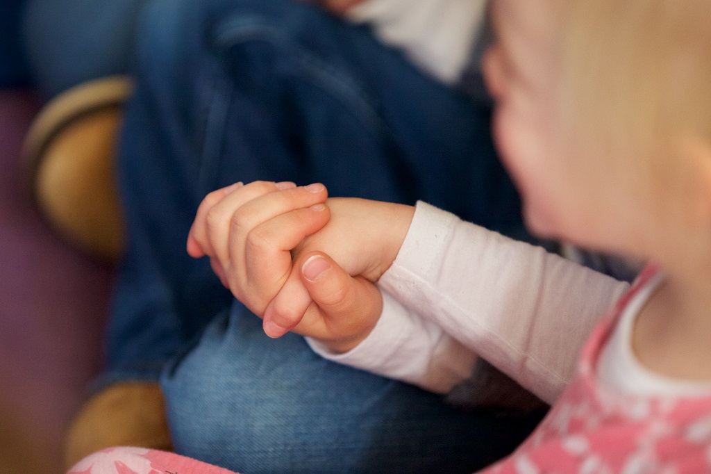 Young child holding an adult’s hand